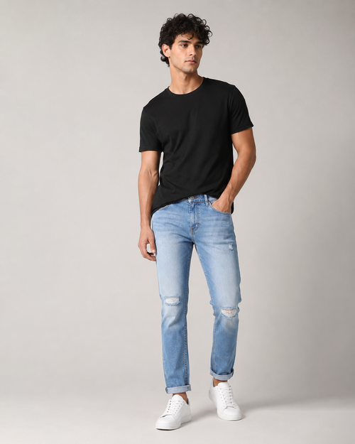 DEZIRE light wash distressed slim jeans for men on a studio model
